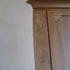 Kitchen cabinets hug a curving, clay plastered wall.