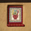 A tile mural set into a clay plastered straw bale wall.